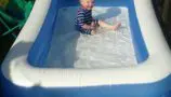 Lucien playing in a paddling pool
