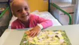 Imogen playing a game during cancer treatment