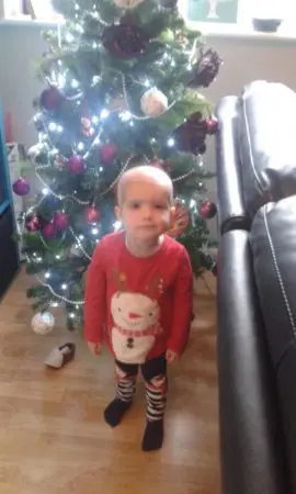 Heidi standing next to a Christmas tree