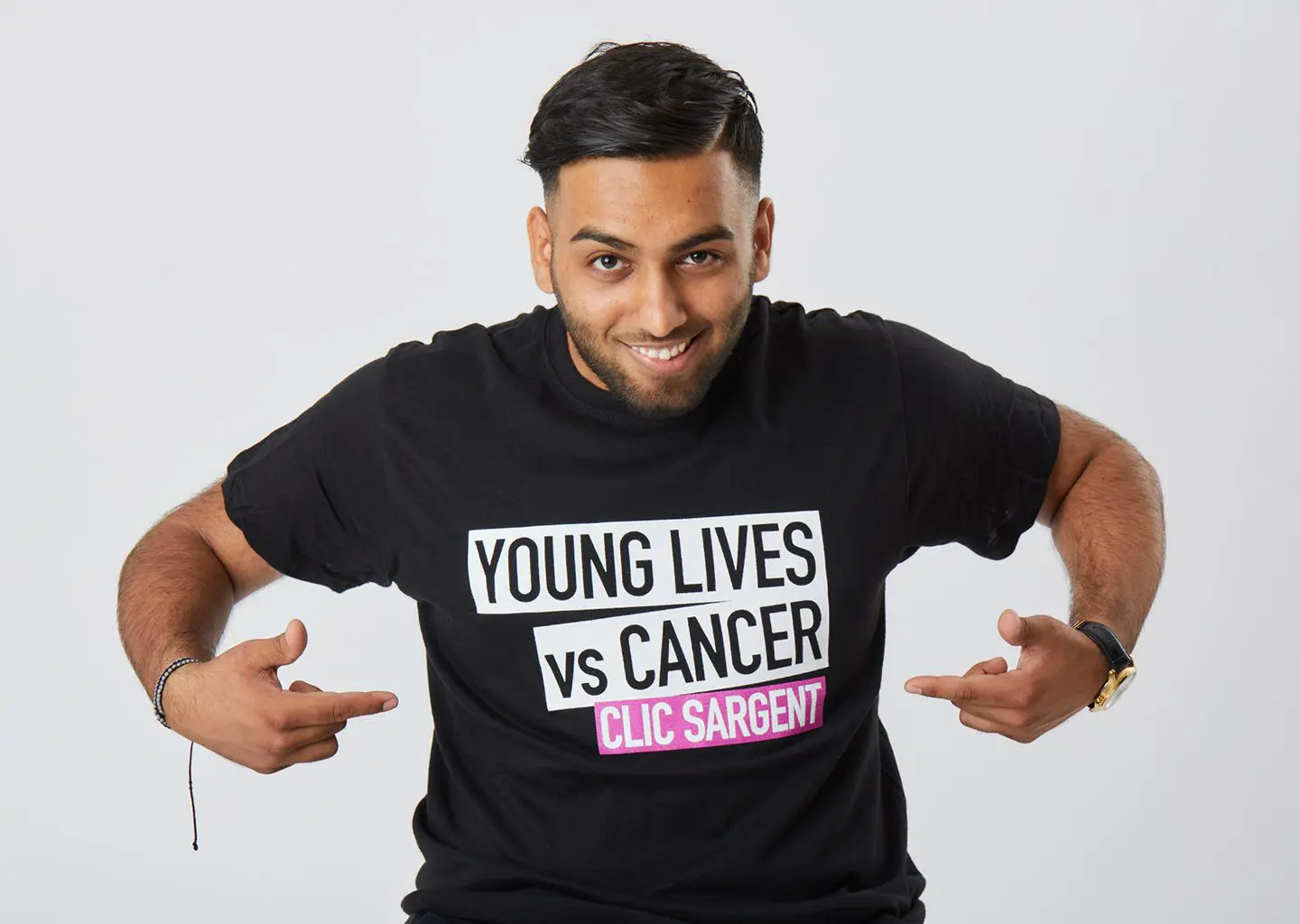 Boy pointing at Young Lives vs Cancer logo on shirt