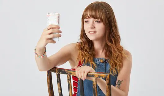 Seren, a young cancer patient CLIC Sargent supported, holding her mobile phone