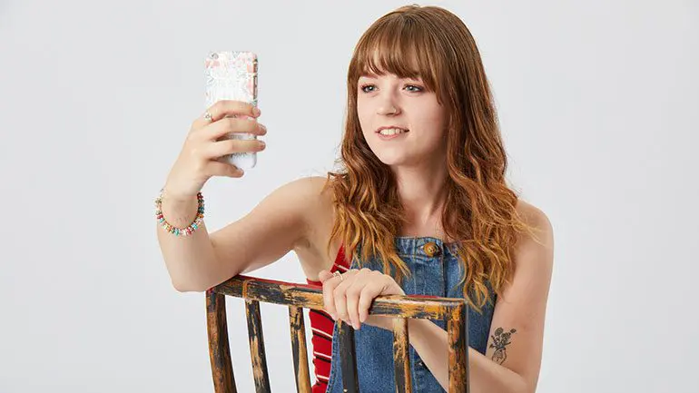 Seren, a young cancer patient CLIC Sargent supported, holding her mobile phone