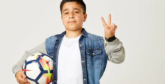 Sofyan, a young cancer patient, holds a football