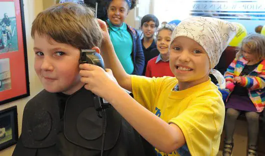 James, 10, having his head shaved by his girlfriend Ivy, who was diagnosed with cancer