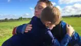 Tim and Michael hugging after Tim completes a skydive for CLIC Sargent