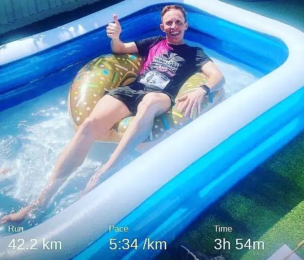 Alex Marsh in his paddling pool after running a marathon in his garden.