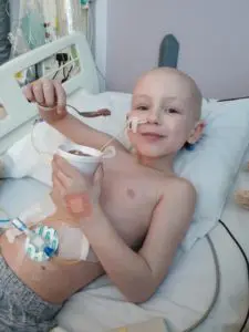 Young cancer patient Kian in hospital eating ice cream