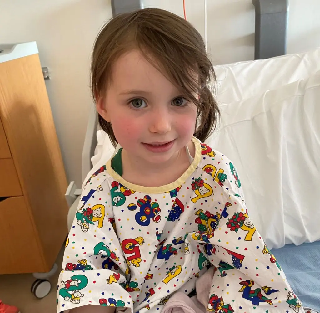 Young cancer patient Imogen sits on a hospital bed