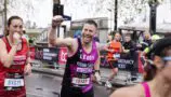 Young Lives vs Cancer London Marathon runner holds fist in triumph while running