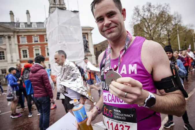 Young Lives vs Cancer London Marathon runner with their medal run