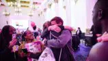 A Young Lives vs Cancer London Marathon runner embraces their family after the event