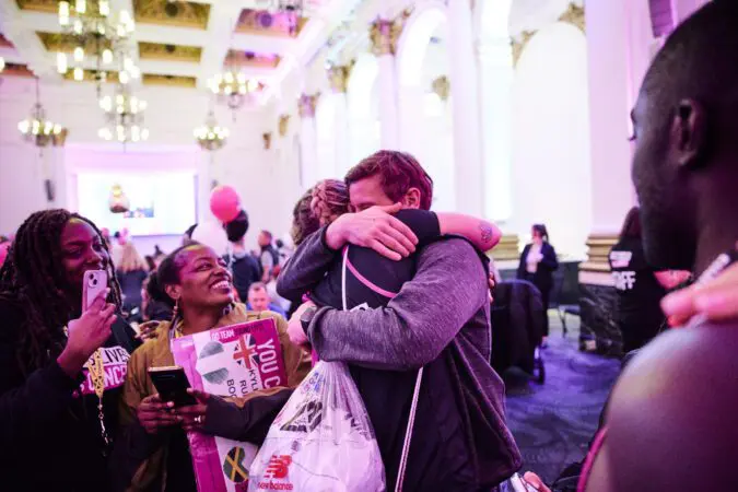 A Young Lives vs Cancer London Marathon runner embraces their family after the event