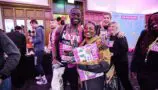 A Young Lives vs Cancer London Marathon runner smiles at the camera with their medal