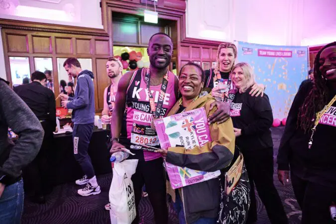 A Young Lives vs Cancer London Marathon runner smiles at the camera with their medal