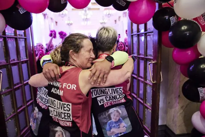 Young Lives vs Cancer London Marathon runners hug in celebration after the event