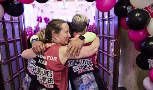 London Marathon runners for Young Lives vs Cancer hug in celebration after the event