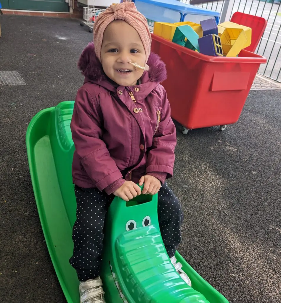 Young cancer patient Aasiyah playing on her rocking toy