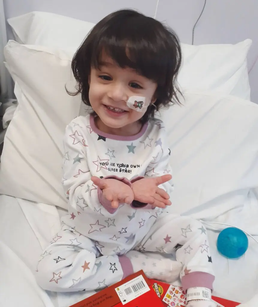 Young cancer patient Aasiyah smiling in a hospital bed