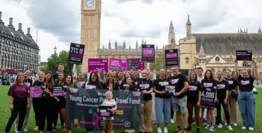 A group of Young Lives vs Cancer campaigners holding placards and banners on Parliament Square
