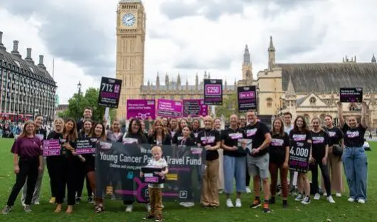 A group of Young Lives vs Cancer campaigners holding placards and banners on Parliament Square