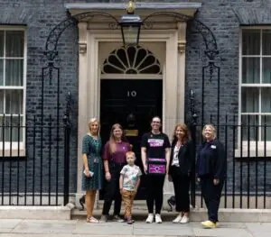 Young people Vic and Dylan standing outside 10 Downing street withour CEO Rachel Kirby-Ryder to hand in our petition at 10 Downing Street