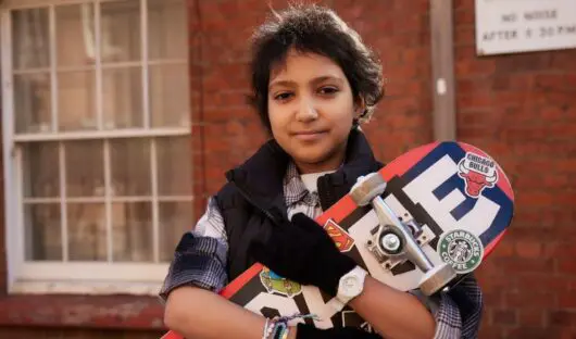 Tia, a young girl, holding a skateboard