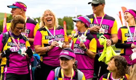 Group of people wearing Young Loves vs Cancer vests, laughing after their challenge