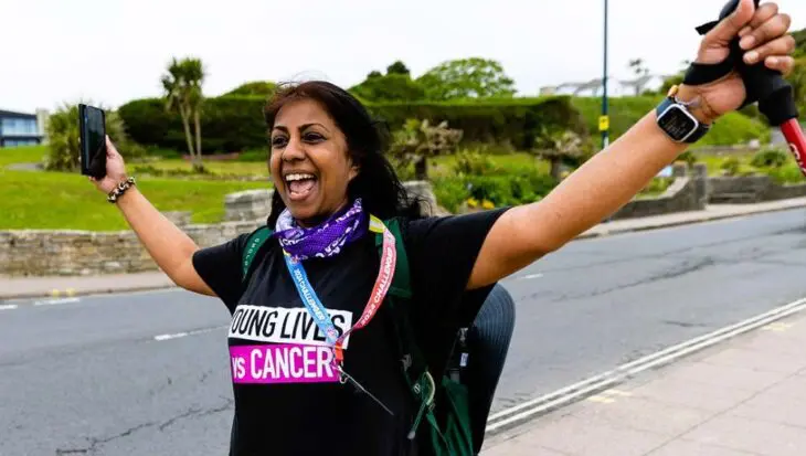 Woman in Young Lives vs Cancer T-shirt, walking looking very happy!