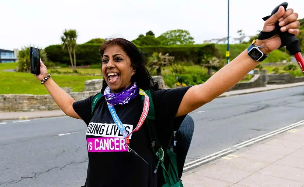 Woman in Young Lives vs Cancer T-shirt, walking looking very happy!