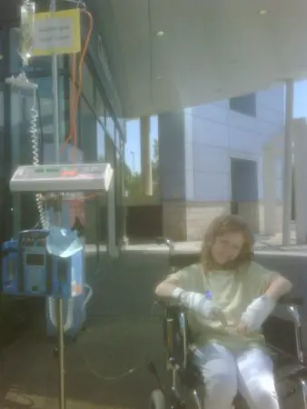 Kate as a child sitting in a wheelchair during cancer treatment