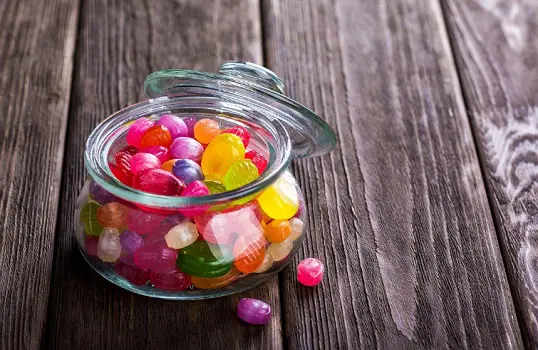 Brightly coloured sweets in a glass jar