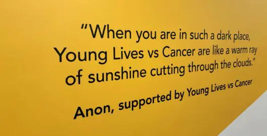 Quote printed on a wall: "When you are in such a dark place, Young Lives vs Cancer are like a warm ray of sunshine cutting through the clouds"