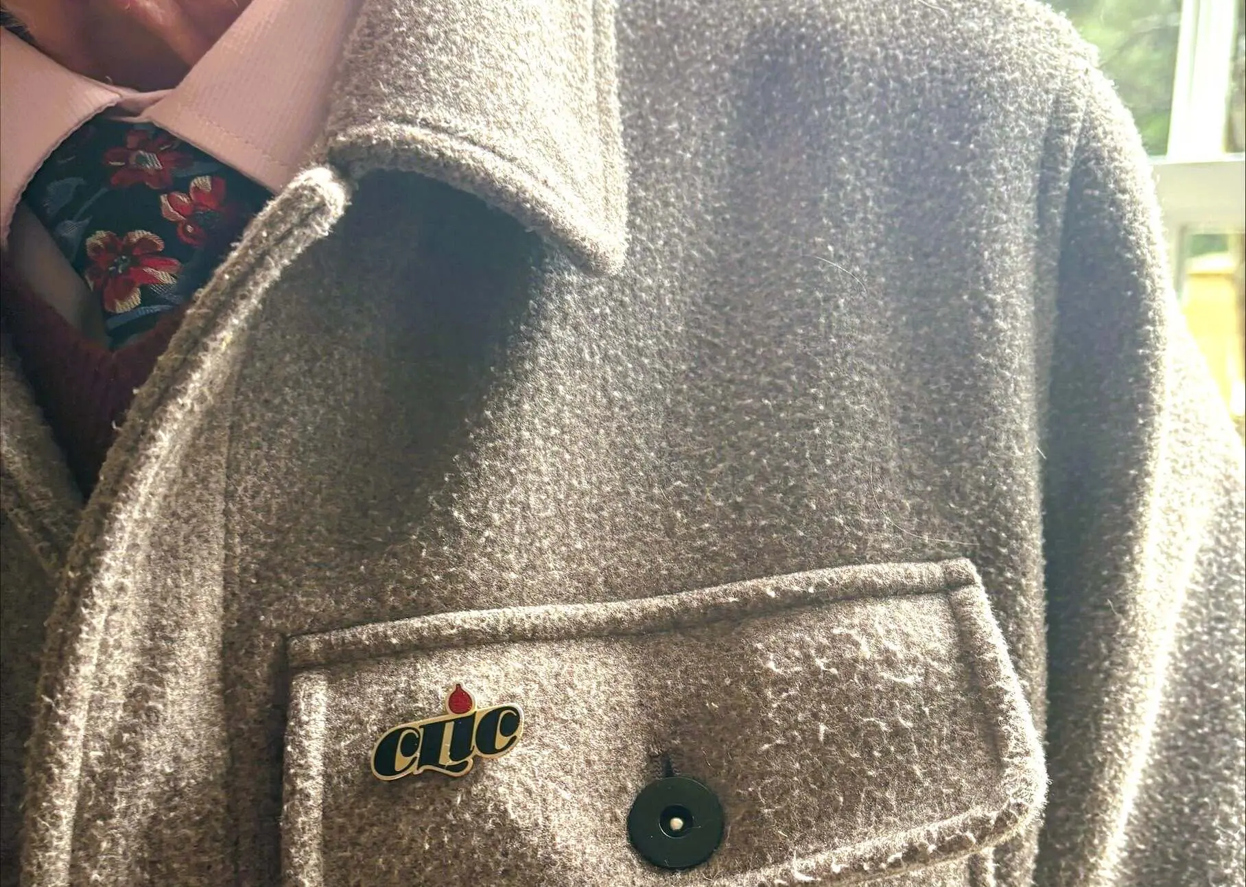 Close up of CLIC pin badge on Mr Greig's jacket
