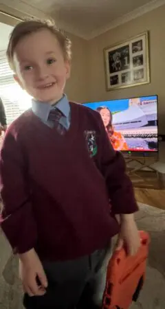 Daithi smiling at the camera in his school uniform