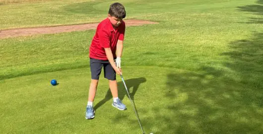 Harry playing golf during a sunny day