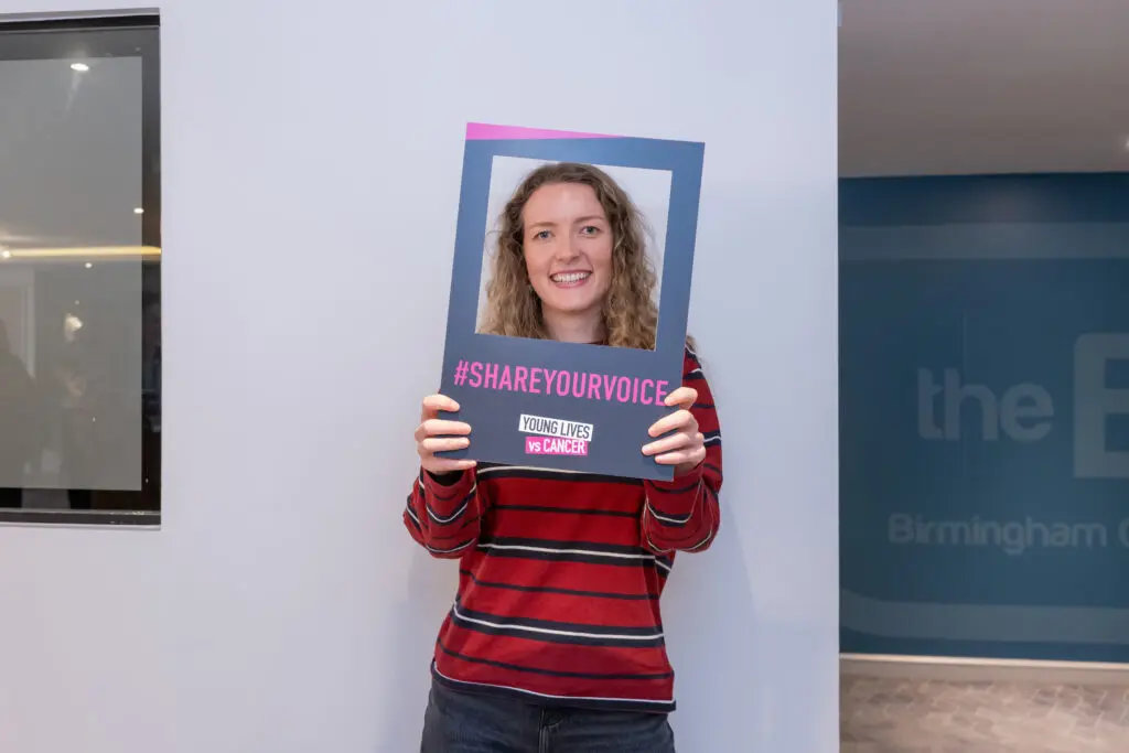 Voice hub member Pippa holding banner saying share your voice