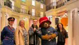 A photographer of 17 year old Jack with his nan Elaine, actor Madeleine Harris, and Paddington Bear at the Paddington Experience during his One Big Thank You surprise