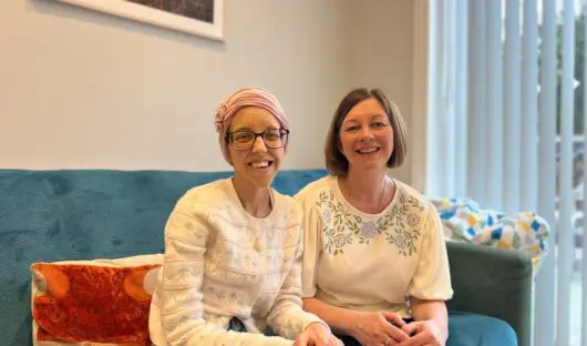 Olivia and Karen at Jack's House. They are sat on the sofa smiling at the camera.