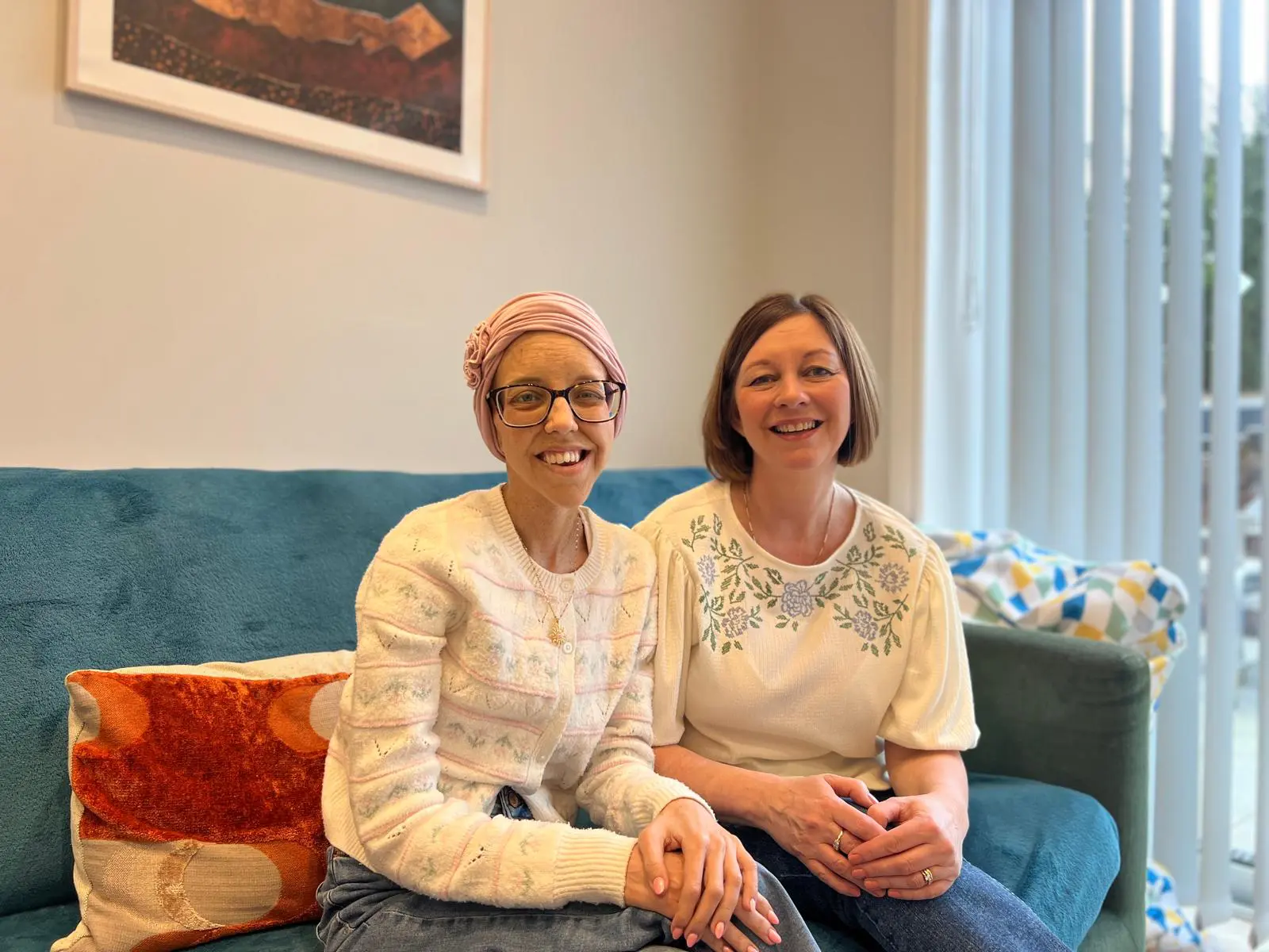 Olivia and Karen at Jack's House. They are sat on the sofa smiling at the camera.