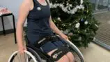 Lucy sat in her wheelchair in front of a christmas tree