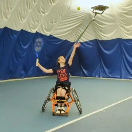 Lucy playing tennis about to serve