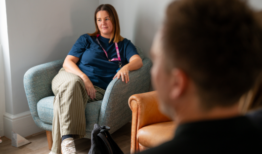 A young lives vs cancer social worker sat talking to a parent.