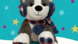 A grey and white bear wearing tartan ear muffs and scarf