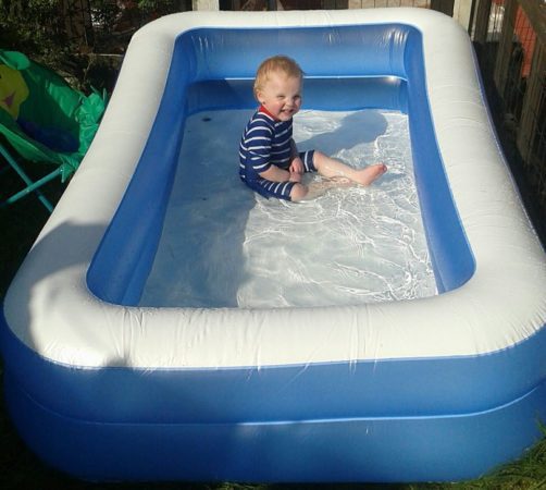 Lucien playing in a paddling pool