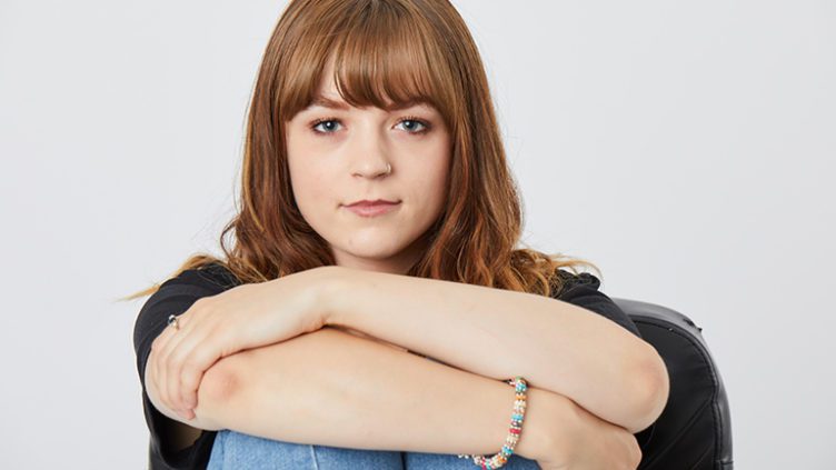 Seren, a young person supported by CLIC Sargent, sat on the floor