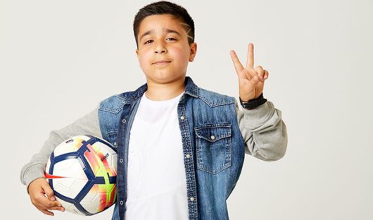 Sofyan, a young cancer patient, holds a football