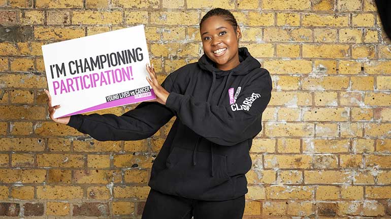Michaela holding I'm Championing Participation board