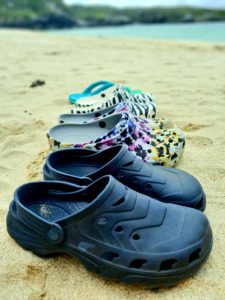 A family's shoes lined up on the beach