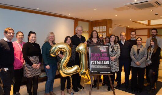 A photo of Young Lives vs Cancer and JDW staff holding up big gold numbers saying 21