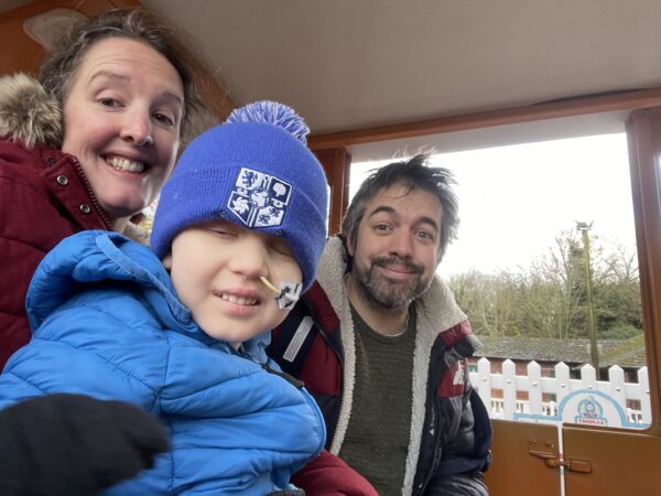Nate pictured in a blue beanie with his mum Nicola and dad Phil
